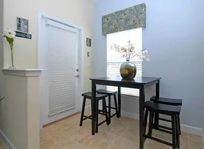 a dining room table with stools and a vase on it at Paradise Palms- 5 Bed Townhome Wsplashpool-3020Pp in Kissimmee