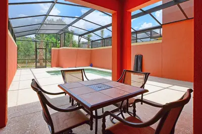 a dining room with a table and chairs on a patio at Dog Friendly Townhouse With Splashpool 3610Pp in Kissimmee