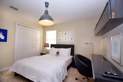 a bedroom with a large white bed and a desk at Family Friendly Home W Game Room 1705Vp in Kissimmee