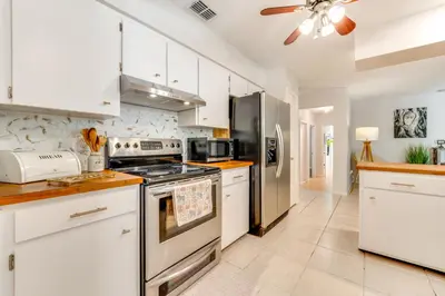 a kitchen with white cabinets and stainless steel appliances at Private Outdoor Oasis with Pool Home in Longwood! in Orlando