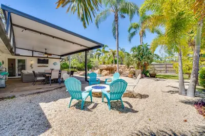 a patio with a table and chairs and palm trees at Private Outdoor Oasis with Pool Home in Longwood! in Orlando
