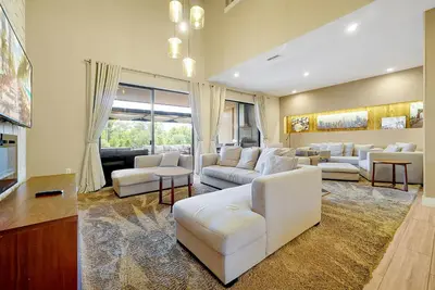 a living room with white furniture and a large window at Magic Village Resort 5 Minutes to Disney!! in Orlando