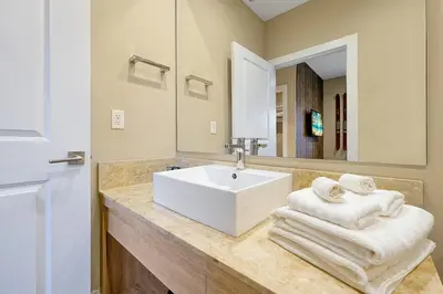 a bathroom with a white sink and a mirror at Magic Village Resort 5 Minutes to Disney!! in Orlando