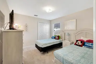 a bedroom with two beds and a flat screen tv at Anthea's Disney Vacation Home in Orlando