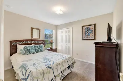 a bedroom with a bed and a television in it at Anthea's Disney Vacation Home in Orlando