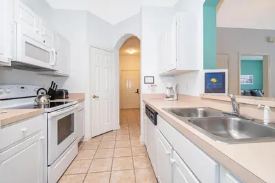 a kitchen with white cabinets and a sink at Beautiful Resort 3 Bedrooms Condo Near Disney in Kissimmee