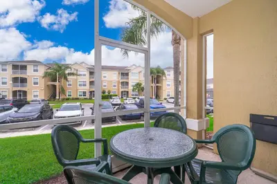 a table and chairs on a patio with a view of a parking lot at Beautiful Resort 3 Bedrooms Condo Near Disney in Kissimmee