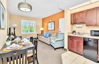 a kitchen and living room with a table and a couch at Chic Apartment near Disney w Pool Hot Tub Arcade in Orlando