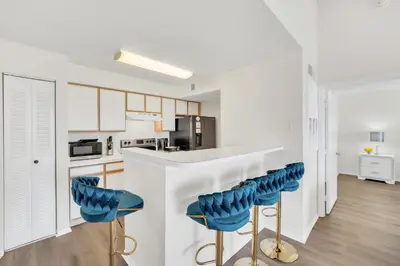 a kitchen with blue bar stools at a counter at Elegant and cozy 2 BD condo near Disney in Kissimmee