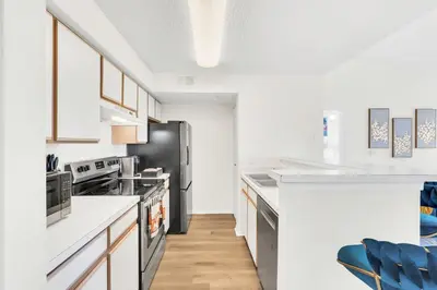 a kitchen with a black refrigerator and white cabinets at Elegant and cozy 2 BD condo near Disney in Kissimmee
