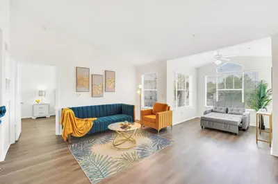 a living room with a blue couch and a chair at Elegant and cozy 2 BD condo near Disney in Kissimmee