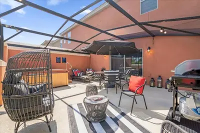 a patio with a bird cage and chairs and an umbrella at 3 Bedrooms 2 Bathrooms Encantada 3070 Wo in Kissimmee