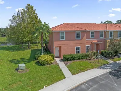a house with a yard with a driveway at 3 Bedrooms 2 Bathrooms Encantada 3070 Wo in Kissimmee