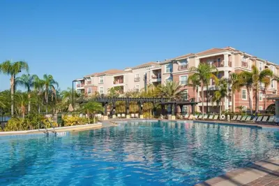 a pool at a resort with palm trees and buildings at 3 Bedrooms 35 Bathrooms Vista Cay 4845-148 in Orlando