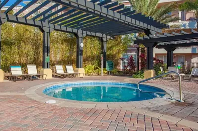 a swimming pool with a pergola and a patio with chairs and a pool at 3 Bedrooms 35 Bathrooms Vista Cay 4845-148 in Orlando