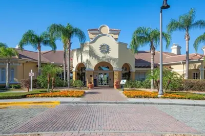 a building with palm trees in front of a street at 3 Bedrooms 35 Bathrooms Vista Cay 4845-148 in Orlando