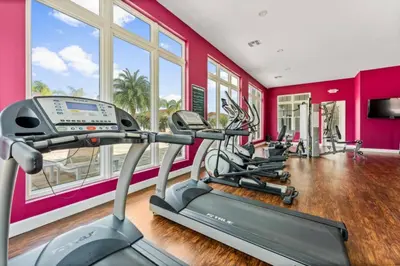 a gym with a row of tread machines in a room at New 4BDR House near Disney 8979 in Kissimmee