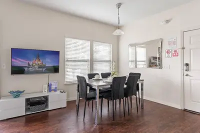 a dining room with a table and black chairs at New 4BDR House near Disney 8979 in Kissimmee