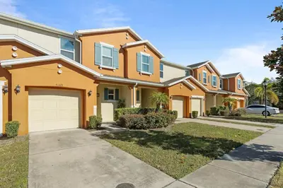 a house with orange paint and a driveway at Family House near Disney - 5109 in Kissimmee