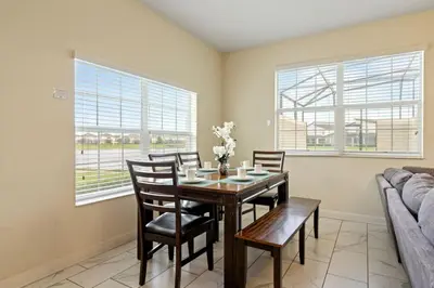 a dining room with a table and chairs and a couch at Amazing 5Bdr House with pool 4857 in Kissimmee