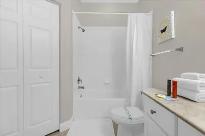 a white bathroom with a toilet and a shower at Luxury 4BDR House close to Parks in Kissimmee