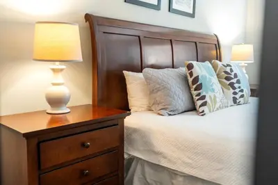 a bedroom with a bed with a lamp on a dresser at 3BR Disney Escape for Families in Kissimmee