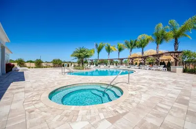 a swimming pool in a patio with palm trees at 3BR Disney Escape for Families in Kissimmee