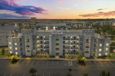 an aerial view of a large building with a parking lot at 3 Bedrooms 2 Bathrooms Storey Lake 3180-308 in Kissimmee
