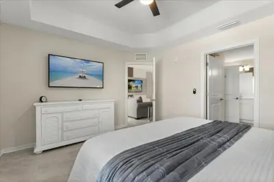a bedroom with a white bed and a tv on the wall at 3 Bedrooms 2 Bathrooms Storey Lake 3180-308 in Kissimmee