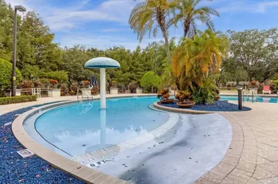 a pool at a resort with palm trees at 4 Bedrooms 3 Bathrooms Lucaya Village 19-104 in Kissimmee