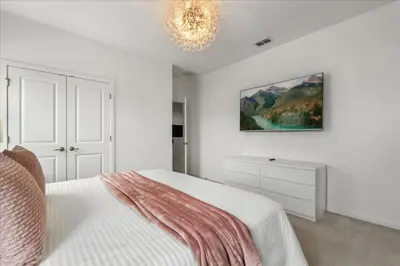 a white bedroom with a bed and a chandelier at 15 Bedrooms155 Bathroomsveranda Palms 2477Rd in Kissimmee