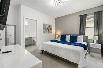 a white bedroom with a large bed with blue pillows at 15 Bedrooms155 Bathroomsveranda Palms 2477Rd in Kissimmee