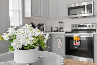 a white vase with white flowers on a table in a kitchen at Entire Disney Retreat Home minutes from Disney, Shopping, and Restaurants 4br,2ba,7beds sleeps 10 in Orlando