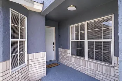 a room with two windows and a white door at Entire Disney Retreat Home minutes from Disney, Shopping, and Restaurants 4br,2ba,7beds sleeps 10 in Orlando