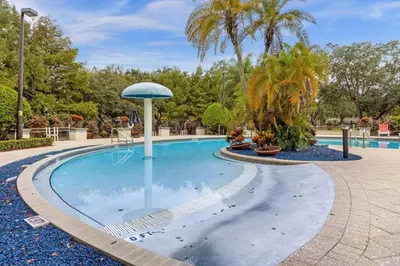 a swimming pool with an umbrella in a park at Perfect vacation spot near Disney 7105 in Kissimmee