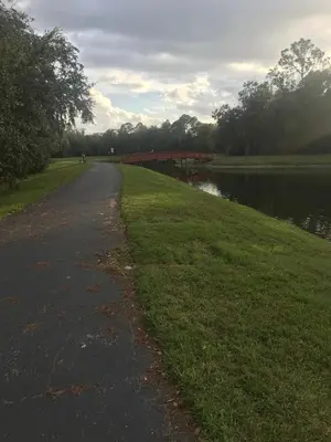 a path next to a river with a bridge at Home Away From Home in Kissimmee