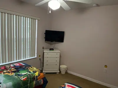 a bedroom with a bed and a flat screen tv at Home Away From Home in Kissimmee