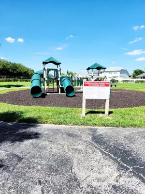 a playground with a slide and a sign next to it at Home Away From Home in Kissimmee