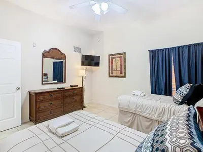 a bedroom with a bed and a dresser and a mirror at 3BR Cozy Apartment at Caribe Cove Resort Near Disney! in Kissimmee
