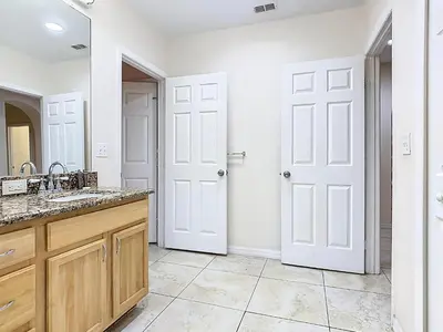 a bathroom with a sink and two white doors at 3BR Cozy Apartment at Caribe Cove Resort Near Disney! in Kissimmee