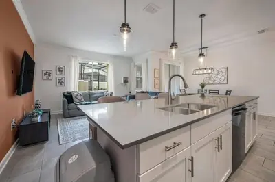 a kitchen with a sink and a living room at Casa c/ Piscina Privativa a 10min da Disney in Kissimmee