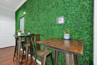 a green wall with two tables and chairs in a room at Cozy 4BR Disney vacation Home7-104 in Kissimmee