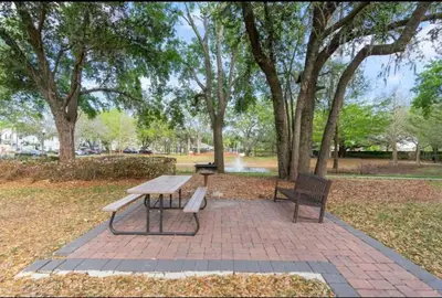 a picnic table and two benches in a park at Cozy 4BR Disney vacation Home7-104 in Kissimmee