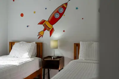 a room with two beds with a rocket on the wall at Cozy 3BDR House near Disney - AL in Orlando