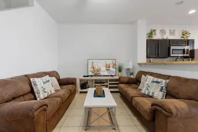 a living room with two brown couches and a table at Cozy 3BDR House near Disney - AL in Orlando