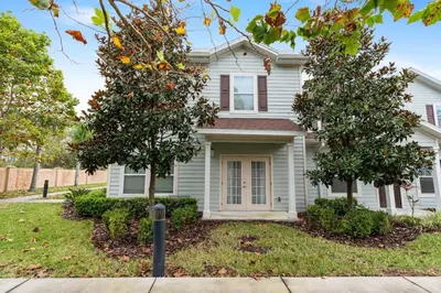 a white house with two trees in front of it at amazing 4bdr house near Disney in Kissimmee
