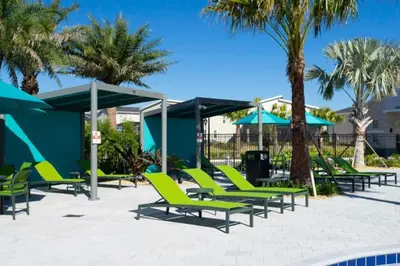 a group of lounge chairs and umbrellas at a resort at Outstanding 5BDR Disney Vacation in Kissimmee