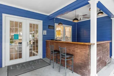 a blue room with a bar with two chairs at Luxury 4 BDR House near Disney 11105 in Kissimmee