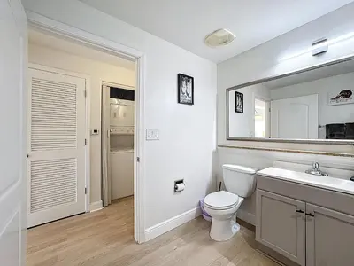 a bathroom with a toilet and a sink and a mirror at Beautiful Orlando Lakefront Condo 5 MINUTES FROM DISNEY in Orlando
