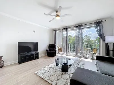 a living room with a couch and a tv at Beautiful Orlando Lakefront Condo 5 MINUTES FROM DISNEY in Orlando